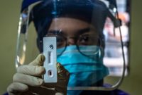 Petugas menunjukkan hasil negatif pada alat pemeriksaan cepat (rapid test) COVID-19 usai memeriksa salah satu pedagang di kawasan Relokasi Pasar Johar, Semarang, Jawa Tengah, Kamis (14/5/2020). Pemeriksaan cepat terhadap sejumlah pedagang di pasar itu guna mengetahui kondisi kesehatan mereka sebagai upaya untuk mencegah penyebaran virus Corona (COVID-19) di tempat keramaian. ANTARA FOTO/Aji Styawan/nz