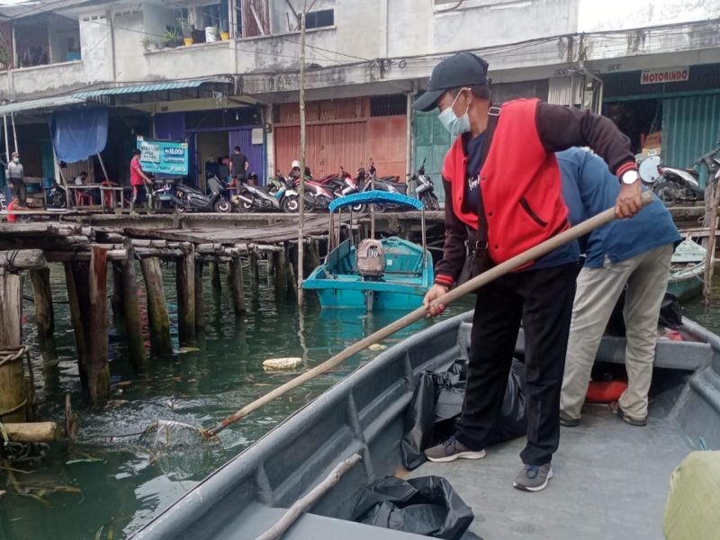 Petugas Dinas Lingkungan Hidup Kota Tanjungpinang membersihkan sampah yang ada di laut. Foto: Istimewa