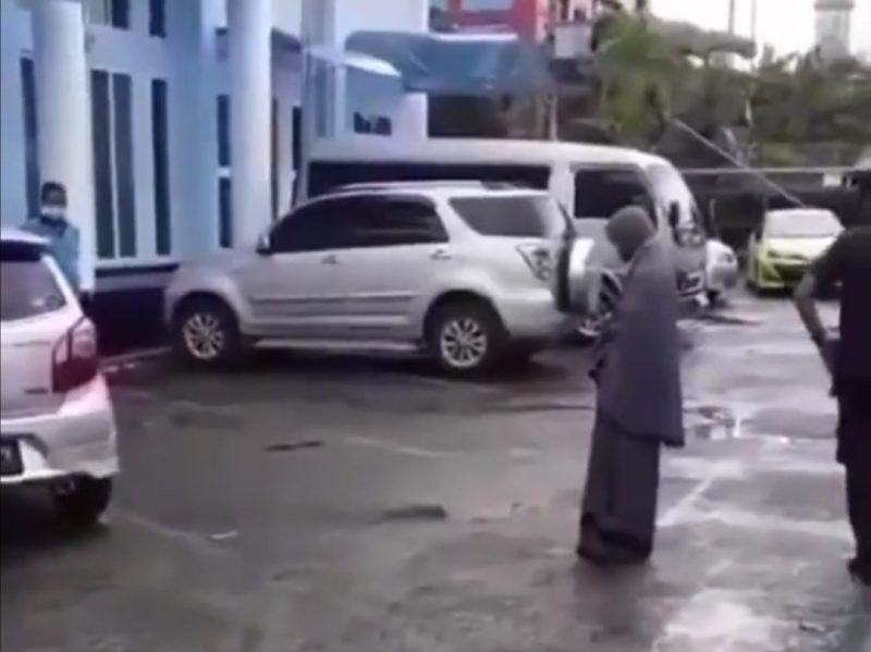 Tangkapan layar video seorang perempuan yang salat di pintu Gereja. Foto: Twitter