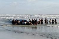 Orang-orang melakukan pencarian korban di pantai Tanjung Balau setelah sebuah kapal yang membawa para migran terbalik, di Kota Tinggi, Johor, Malaysia, 15 Desember 2021. Foto: Royal Malaysian Army/Handout via REUTERS