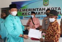 Kadisdukcapil Kota Batam Heryanto SE menyerahkan secara simbolis dokumen Kependudukan warga korban kebakaran di Pulau Buluh. Foto: Istimewa