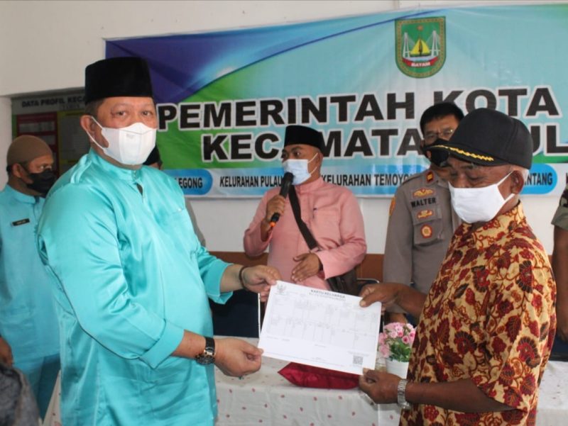 Kadisdukcapil Kota Batam Heryanto SE menyerahkan secara simbolis dokumen Kependudukan warga korban kebakaran di Pulau Buluh. Foto: Istimewa