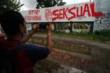 Warga memotret mural stop kekerasan seksual. Foto: ANTARA