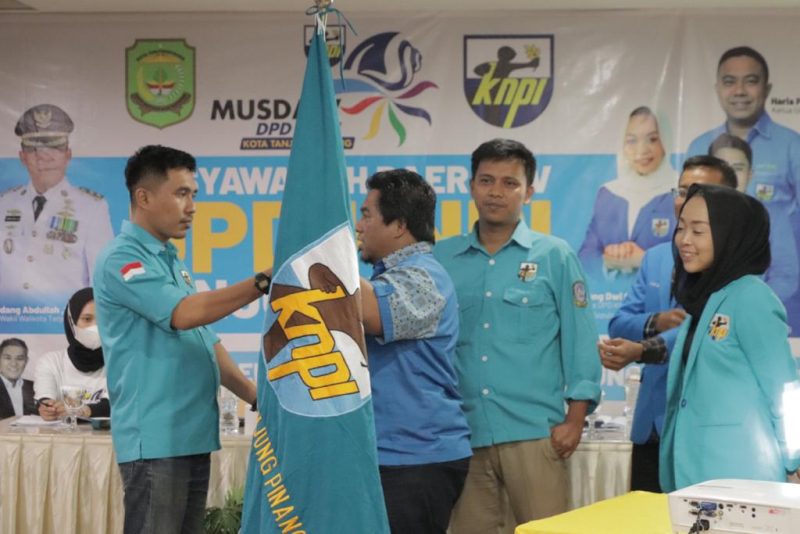 Dimas Prayoga (kiri) menerima bendera pataka setelah terpilih secara aklamasi menjadi ketua DPD KNPI Kota Tanjungpinang periode 2022-2025. Foto: INIKEPRI.COM 