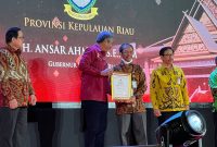 Kepala Badan Kepegawaian Daerah dan Korpri Kepri Firdaus mewakili Gubernur Ansar Ahmad menerima penghargaan. Foto: Diskominfo Kepri 