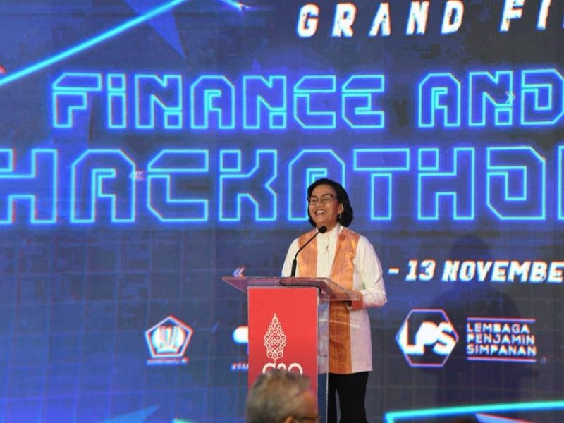 Menteri Keuangan Sri Mulyani menyampaikan pidato pada Finance & Health Hackaton 2022 di Nusa Dua, Bali, Minggu (13/11). Menkeu mengenakan atasan dari bahan Tenun Buku Sulawesi warna putih motif rintik hujan. Foto: InfoPublik 