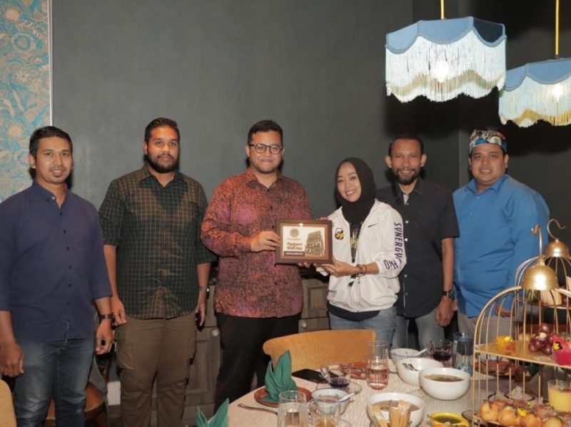 Presiden Majlis Belia Malaysia (MBM) Mohd Izzat Afifi Abdul Hamid memberikan kenang-kenangan kepada ketua DPD KNPI Kepri Dewi Socowati didampingi ketua BP KNPI Malaysia Tengku Adnan. Foto: INIKEPRI.COM 