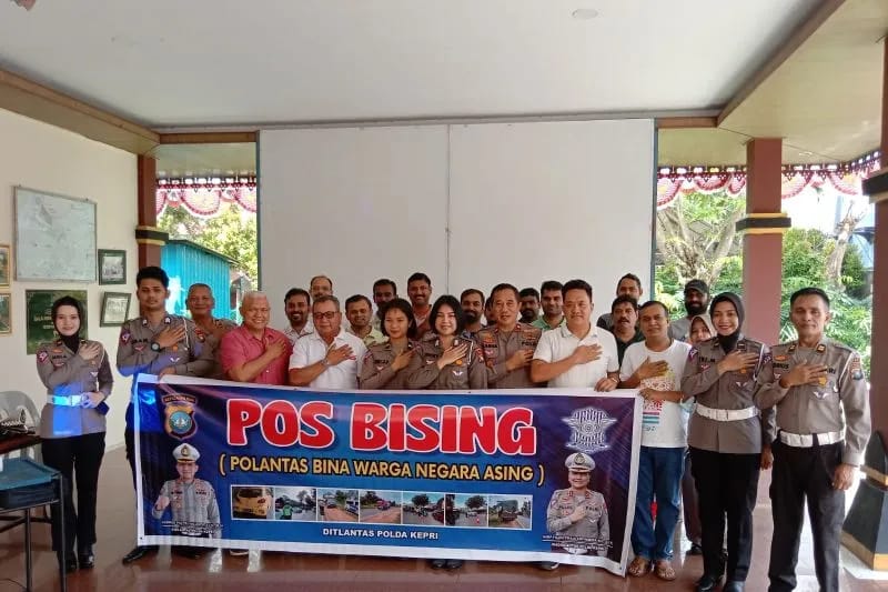 Personel Ditlantas Polda Kepri foto bersama dengan WNA yang ikut penyuluhan tertib lalu lintas di Batam, Minggu (5/2). Foto: ANTARA/HO-Ditlantas Polda Kepri