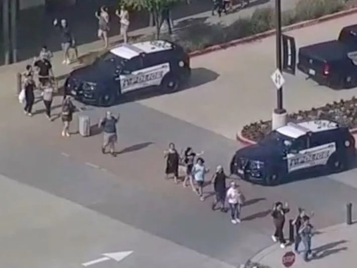 Pengunjung keluar mal dengan tangan terangkat saat polisi menanggapi insiden penembakan di Allen Premium Outlets di daerah Dallas, yang menurut pihak berwenang telah menyebabkan banyak orang terluka di Allen, Texas, AS, 6 Mei 2023, dalam gambar diam dari video. Foto: Afiliasi ABC WFAA via REUTERS/as