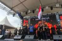 Ketua Paguyuban Keluarga Besar Arema Batam (PKBAB) Kota Batam Teguh Dia Mafianto, mengibarkan bendera pataka. Foto: INIKEPRI.COM 