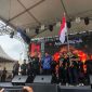 Ketua Paguyuban Keluarga Besar Arema Batam (PKBAB) Kota Batam Teguh Dia Mafianto, mengibarkan bendera pataka. Foto: INIKEPRI.COM 