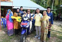Ketua TP-PKK Provinsi Kepulauan Riau Hj. Dewi Kumalasari Ansar menyerahkan bantuan berupa 1 unit Kendaraan Bermotor Roda 3 kepada masyarakat Sei Nam Kijang, Kabupaten Bintan, Jumat (24/11). Foto: Diskominfo Kepri 