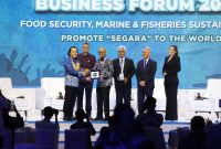 Asisten Khusus Menteri Kelautan dan Perikanan Bidang Media dan Komunikasi Publik, Doni Ismanto menyerahkan buku 'Perjalanan 25 Tahun Menata Segara' kepada Direktur Pengembangan Bisnis dan Pengendalian ID Food Dirgayuza Setiawan, dalam acara Indonesia Marine and Fishries Business Forum (IMFBF) 2024 di Jakarta. Foto: Dok KKP