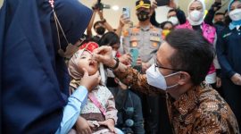 Menkes Budi berikan imunisasi tetes pada anak. Foto: Kemenkes