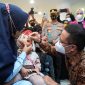 Menkes Budi berikan imunisasi tetes pada anak. Foto: Kemenkes