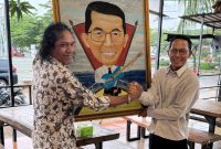 Parlindungan Yudha Marbun saat memberikan lukisan karyanya kepada Amsakar Achmad. Foto: INIKEPRI.COM