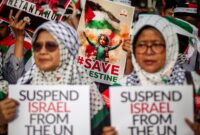Pengunjuk rasa memegang poster saat mengikuti aksi solidaritas untuk rakyat Palestina di depan Kedutaan Besar Amerika Serikat, Jakarta, Jumat (29/11/2024). Aksi tersebut digelar sebagai bentuk dukungan di Hari Solidaritas Internasional Bersama Rakyat Palestina atau International Day of Solidarity with the Palestinian People yang diperingati secara serentak di seluruh dunia sejak 1978. Foto: Dhemas Reviyanto/YU