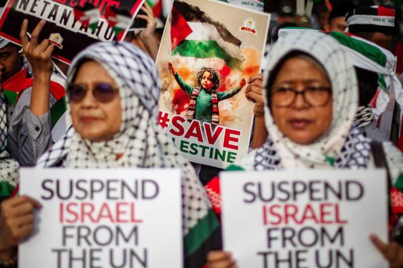 Pengunjuk rasa memegang poster saat mengikuti aksi solidaritas untuk rakyat Palestina di depan Kedutaan Besar Amerika Serikat, Jakarta, Jumat (29/11/2024). Aksi tersebut digelar sebagai bentuk dukungan di Hari Solidaritas Internasional Bersama Rakyat Palestina atau International Day of Solidarity with the Palestinian People yang diperingati secara serentak di seluruh dunia sejak 1978. Foto: Dhemas Reviyanto/YU