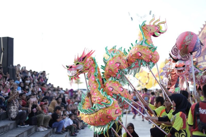 Festival 9 Naga yang berlangsung di Pelataran Tugu Sirih, Kawasan Gurindam 12, Tanjungpinang, Kepulauan Riau, Sabtu (7/12/2024), sukses menarik perhatian banyak warga.Pengunjung memanfaatkan akhir pekan untuk menikmati beragam pertunjukan budaya dan seni tradisional seperti atraksi 9 naga, reog, dan kesenian lainnya.Asisten Administrasi Perekonomian dan Pembangunan Kota Tanjungpinang, Elfiani Sandri, mengapresiasi suksesnya festival ini. Menurutnya, Festival 9 Naga dapat menjadi daya tarik wisatawan domestik dan internasional.“Festival ini bermanfaat bagi semua pihak, menghidupkan sektor pariwisata, dan mendorong PAD. Semoga pariwisata Tanjungpinang semakin maju dan berkembang,” ujar Elfiani dalam sambutannya.Elfiani juga mengucapkan terima kasih kepada semua pihak yang mendukung terlaksananya acara ini. “Semoga festival ini menjadi kebanggaan bersama dan dapat memperkenalkan budaya lokal kepada masyarakat luas,” tambahnya.Ketua DPRD Kota Tanjungpinang, Agus Djurianto, berharap ke depan Festival 9 Naga dapat semakin semarak dengan melibatkan lebih banyak komunitas budaya.“Tanjungpinang adalah kota kecil yang indah dan penuh keberagaman. Festival seperti ini mempererat persatuan dan melestarikan budaya. Semoga tahun depan acaranya lebih meriah dan semakin memperkuat identitas kebangsaan kita,” kata Agus.Sebelumnya, Sekretaris Dinas Kebudayaan dan Pariwisata Kota Tanjungpinang, Mulia Wiwin, melaporkan Festival 9 Naga 2024 merupakan upacara keselamatan untuk menghormati leluhur. Festival ini juga menunjukkan komitmen pemerintah dalam melestarikan berbagai etnis dan budaya, terutama budaya Tionghoa di Tanjungpinang.“Festival 9 Naga bukan hanya perayaan seni dan budaya Tionghoa, tetapi juga simbol kebersamaan dalam keragaman yang menjadi identitas bangsa,” ujar Mulia.Acara ini turut dihadiri unsur Forkopimda, anggota DPRD Provinsi Kepri, perwakilan Dispar Kepri, Balai Pelestarian Budaya Wilayah IV, pejabat pemko Tanjungpinang, ketua paguyuban warga Tionghoa, serta tokoh agama. Foto: Diskominfo Tanjungpinang 