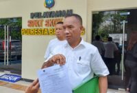Akhmad Rosano menunjukkan laporannya terhadap Yusril Koto ke para awak media. Foto : INIKEPRI.COM/Tengku Bayu