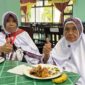 Calon jamaah haji di Embarkasi Batam menikmati menu makanan. Foto: INIKEPRI.COM