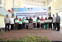 Wali Kota Batam, Amsakar Achmad, menyerahkan secara simbolis kartu peserta dan santunan jaminan sosial ketenagakerjaan kepada petani penerima manfaat di Plaza TOP 100 Tembesi, Rabu (4/6/2025). Foto: INIKEPRI.COM
