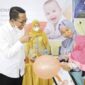 Wali Kota Batam, Amsakar Achmad, tersenyum hangat saat bercengkerama dengan seorang bayi yang digendong ibunya dalam kegiatan pemantauan tumbuh kembang anak. Sentuhan langsung sang pemimpin mencerminkan keseriusan Batam dalam mewujudkan generasi bebas stunting—dimulai dari yang paling kecil, dan yang paling berharga. Foto: INIKEPRI.COM
