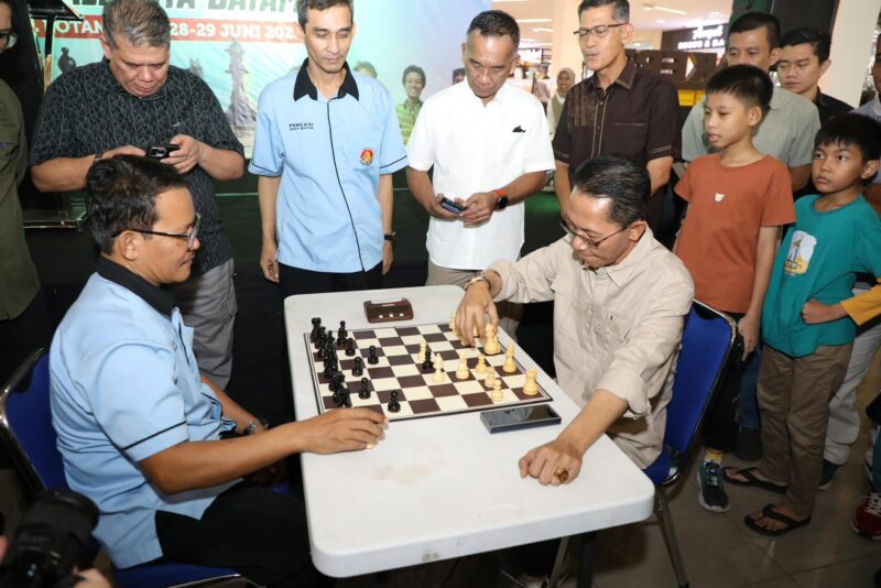 Wali Kota Batam, Amsakar Achmad, berhadapan langsung dengan Ketua Persatuan Catur Seluruh Indonesia (Percasi) Batam, Suhandri, di atas papan catur saat pembukaan Turnamen Catur Divisi Utama dan Non Master yang digelar Percasi Kota Batam di MB2 Mall, Sabtu (28/6/2025). Foto: INIKEPRI.COM