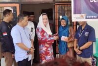 Bupati Natuna, Cen Sui Lan, secara simbolis menyerahkan Bantuan Sosial Tunai (BST) kepada salah satu lansia penerima manfaat di Kantor Pos Ranai, Kecamatan Bunguran Timur, Jumat (20/6/2025). Kegiatan ini merupakan bagian dari upaya pemerintah daerah dalam menanggulangi kemiskinan ekstrem di wilayah Natuna. Turut mendampingi sejumlah pejabat daerah, petugas Pos Indonesia, serta aparat keamanan setempat. Foto: Faturrahman/HK