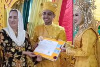 Bupati Natuna, Cen Sui Lan, secara simbolis menyerahkan dokumen Kartu Keluarga (KK) kepada pasangan pengantin baru di Kecamatan Pulau Tiga pada Minggu (29/6/2025). Foto: Tangkapan Layar TikTok 