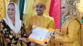 Bupati Natuna, Cen Sui Lan, secara simbolis menyerahkan dokumen Kartu Keluarga (KK) kepada pasangan pengantin baru di Kecamatan Pulau Tiga pada Minggu (29/6/2025). Foto: Tangkapan Layar TikTok 