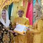 Bupati Natuna, Cen Sui Lan, secara simbolis menyerahkan dokumen Kartu Keluarga (KK) kepada pasangan pengantin baru di Kecamatan Pulau Tiga pada Minggu (29/6/2025). Foto: Tangkapan Layar TikTok