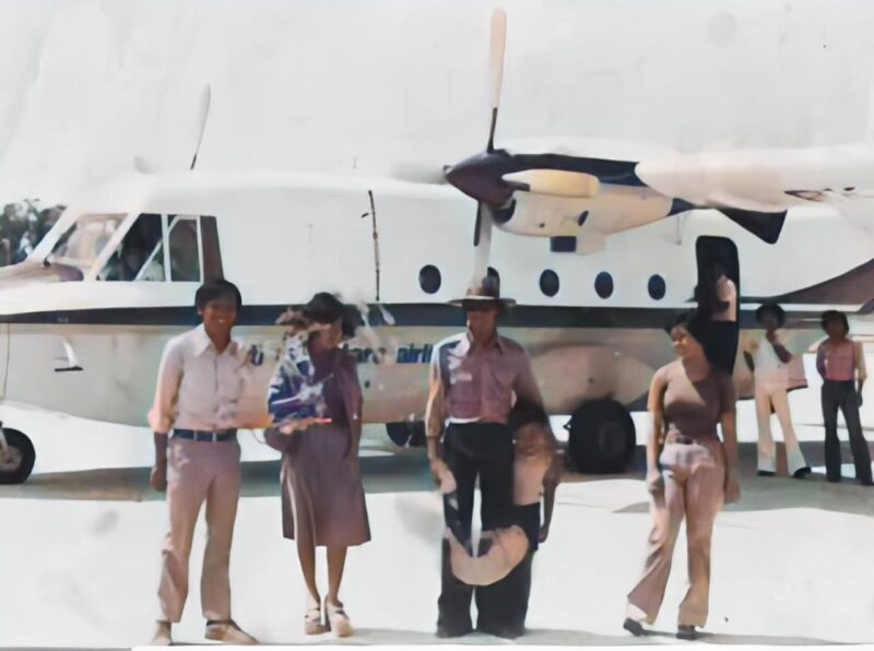 Drs. Hari Soekoraharjo, pegawai Otorita Batam, terlihat berdiri bersama rombongan di depan pesawat Merpati Nusantara Airlines (MNA) sesaat setelah mendarat di Hang Nadim, tahun 1979. Potret ini menjadi saksi awal geliat penerbangan di Batam. Foto: Istimewa 