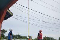 Petugas PLN Belakangpadang mengambil layangan yang menyangkut di jaringan kabel listrik di wilayah setempat. Foto: INIKEPRI.COM