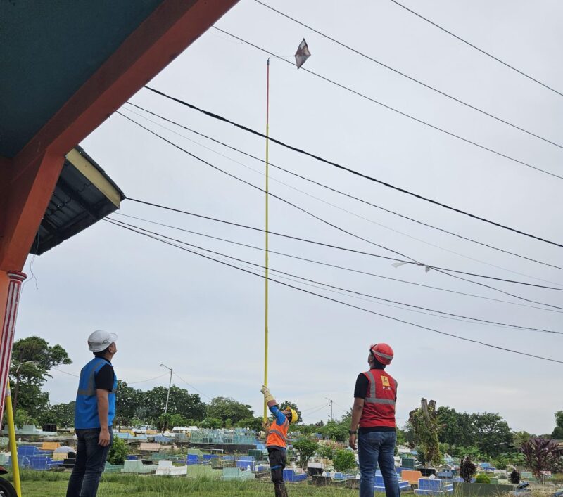 Petugas PLN Belakangpadang mengambil layangan yang menyangkut di jaringan kabel listrik di wilayah setempat. Foto: INIKEPRI.COM