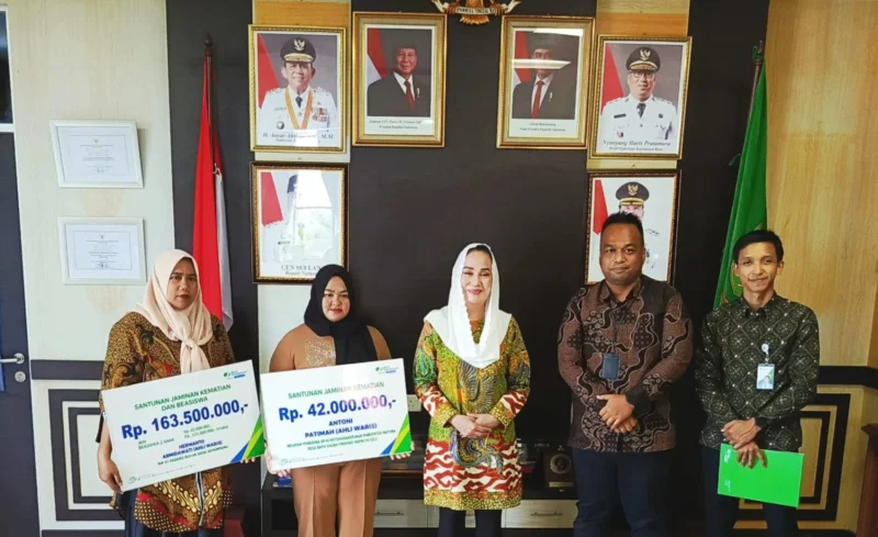 Bupati Natuna, Cen Sui Lan (tengah), secara simbolis menyerahkan santunan jaminan kematian dan beasiswa pendidikan kepada dua ahli waris nelayan, Armidawati (kiri) dan Fatimah (kedua dari kiri), di ruang kerjanya, Kamis (30/7/2025). Santunan senilai total Rp205,5 juta tersebut berasal dari program BPJS Ketenagakerjaan yang iurannya ditanggung pemerintah. Hadir dalam kesempatan itu perwakilan BPJS Ketenagakerjaan Natuna dan jajaran terkait. Foto: Istimewa