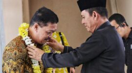 Gubernur Kepri Ansar Ahmad mengalungkan karangan bunga kepada Jehezkiel Devy Sudarso, Kajati Kepri yang baru di Bandara Raja Haji Fisabilillah Tanjungpinang, Jumat (18/7/2025). Foto: INIKEPRI.COM/Diskominfo Kepri