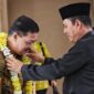 Gubernur Kepri Ansar Ahmad mengalungkan karangan bunga kepada Jehezkiel Devy Sudarso, Kajati Kepri yang baru di Bandara Raja Haji Fisabilillah Tanjungpinang, Jumat (18/7/2025). Foto: INIKEPRI.COM/Diskominfo Kepri