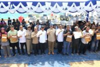 Menteri Transmigrasi Muhammad Iftitah Sulaiman Suryanagara dan Wali Kota Batam sekaligus Kepala BP Batam Amsakar Achmad berfoto bersama warga penerima Sertifikat Hak Milik (SHM) di Tanjung Banon, Kecamatan Galang, Batam, Selasa (12/8/2025). Penyerahan 94 sertifikat ini menjadi bagian dari program relokasi warga Rempang dalam pembangunan Rempang Eco-City. Foto: INIKEPRI.COM
