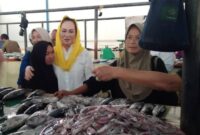 Momen Cen Sui Lan menyapa dan merangkul pedagang ikan saat kampanye Pilbup Natuna 2025 di pasar tradisional. Foto: Arsip 