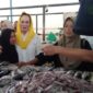 Momen Cen Sui Lan menyapa dan merangkul pedagang ikan saat kampanye Pilbup Natuna 2025 di pasar tradisional. Foto: Arsip 