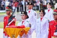 Tsaniyah Aqillah Muca I Kadek membawa replika Sangska Merah Putih yang diserahkan Gubernur Kepri Ansar Ahmad dalam upacara Peringatan HUT RI ke-80 Tingkat Provinsi Kepri di Gedung Daerah, Minggu (17/8/2025). Foto: INIKEPRI.COM/KepriProv 