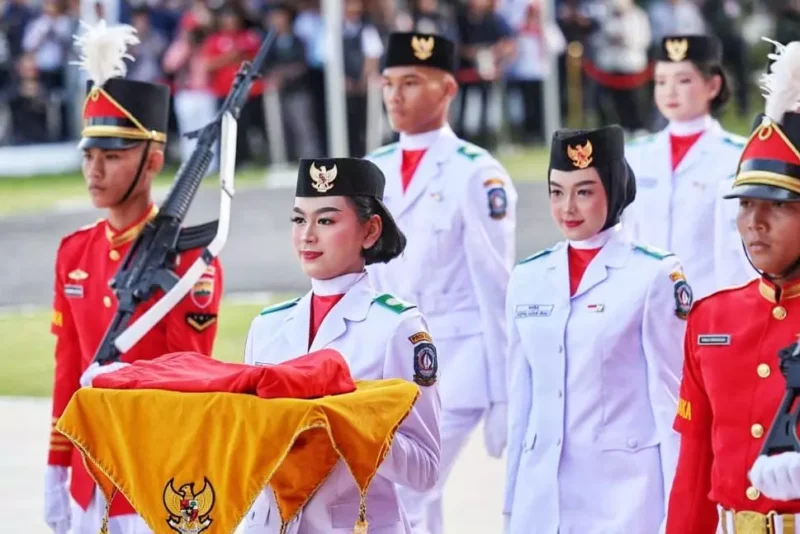 Tsaniyah Aqillah Muca I Kadek membawa replika Sangska Merah Putih yang diserahkan Gubernur Kepri Ansar Ahmad dalam upacara Peringatan HUT RI ke-80 Tingkat Provinsi Kepri di Gedung Daerah, Minggu (17/8/2025). Foto: INIKEPRI.COM/KepriProv 