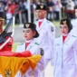 Tsaniyah Aqillah Muca I Kadek membawa replika Sangska Merah Putih yang diserahkan Gubernur Kepri Ansar Ahmad dalam upacara Peringatan HUT RI ke-80 Tingkat Provinsi Kepri di Gedung Daerah, Minggu (17/8/2025). Foto: INIKEPRI.COM/KepriProv 