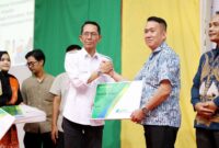 Wali Kota Batam, Amsakar Achmad, menyerahkan kartu kepesertaan BPJS Ketenagakerjaan secara simbolis kepada perwakilan Ketua RT se-Kota Batam pada peluncuran program jaminan sosial bagi 24.300 pekerja rentan dan tokoh masyarakat, Jumat (26/9/2025) di Golden Prawn. Foto: INIKEPRI.COM