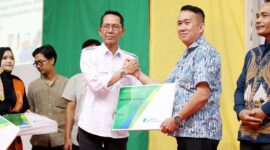 Wali Kota Batam, Amsakar Achmad, menyerahkan kartu kepesertaan BPJS Ketenagakerjaan secara simbolis kepada perwakilan Ketua RT se-Kota Batam pada peluncuran program jaminan sosial bagi 24.300 pekerja rentan dan tokoh masyarakat, Jumat (26/9/2025) di Golden Prawn. Foto: INIKEPRI.COM