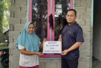 Saraini, istri almarhum Edi (atlit Pacu Jalur ATOM), menerima bantuan beasiswa Rp15 juta dari Bupati Natuna Cen Sui Lan dan Raja Mustakim yang diserahkan melalui Ustad Dr. Roni Putra, M.Pd, di kediamannya Desa Simandolak, Ahad (14/9/2025). Foto: Istimewa 