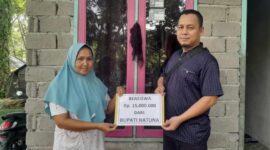 Saraini, istri almarhum Edi (atlit Pacu Jalur ATOM), menerima bantuan beasiswa Rp15 juta dari Bupati Natuna Cen Sui Lan dan Raja Mustakim yang diserahkan melalui Ustad Dr. Roni Putra, M.Pd, di kediamannya Desa Simandolak, Ahad (14/9/2025). Foto: Istimewa 