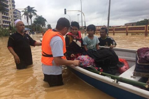 Petugas penyelamat membantu mengungsikan korban banjir ke tempat pengungsian. Foto: The Star Online Malaysia