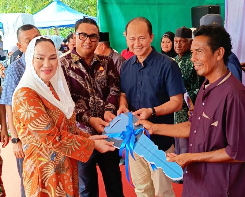 Bupati Natuna Cen Sui Lan bersama jajaran pemerintah daerah menyerahkan kunci rumah layak huni secara simbolis kepada perwakilan warga Batu Kapal pada kegiatan peresmian 57 unit hunian di Kampung Puak, Minggu (23/11). Foto: Istimewa 